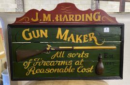 A reproduction painted wood 'Gunmaker' sign, width 90cm, height 61cm