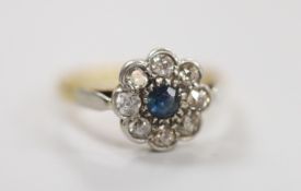 A 1940's yellow metal and plat, sapphire and diamond set circular cluster ring, size O, gross weight