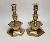A pair of Scandinavian, possibly 17th century, brass candlesticks, dated 1644, each with a shield