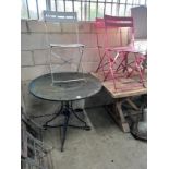 A circular metal and wrought iron garden table, diameter 90cm, and three chairs