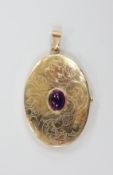 A modern engraved 9ct gold and cabochon garnet set oval pendant locket, overall 56mm, gross weight