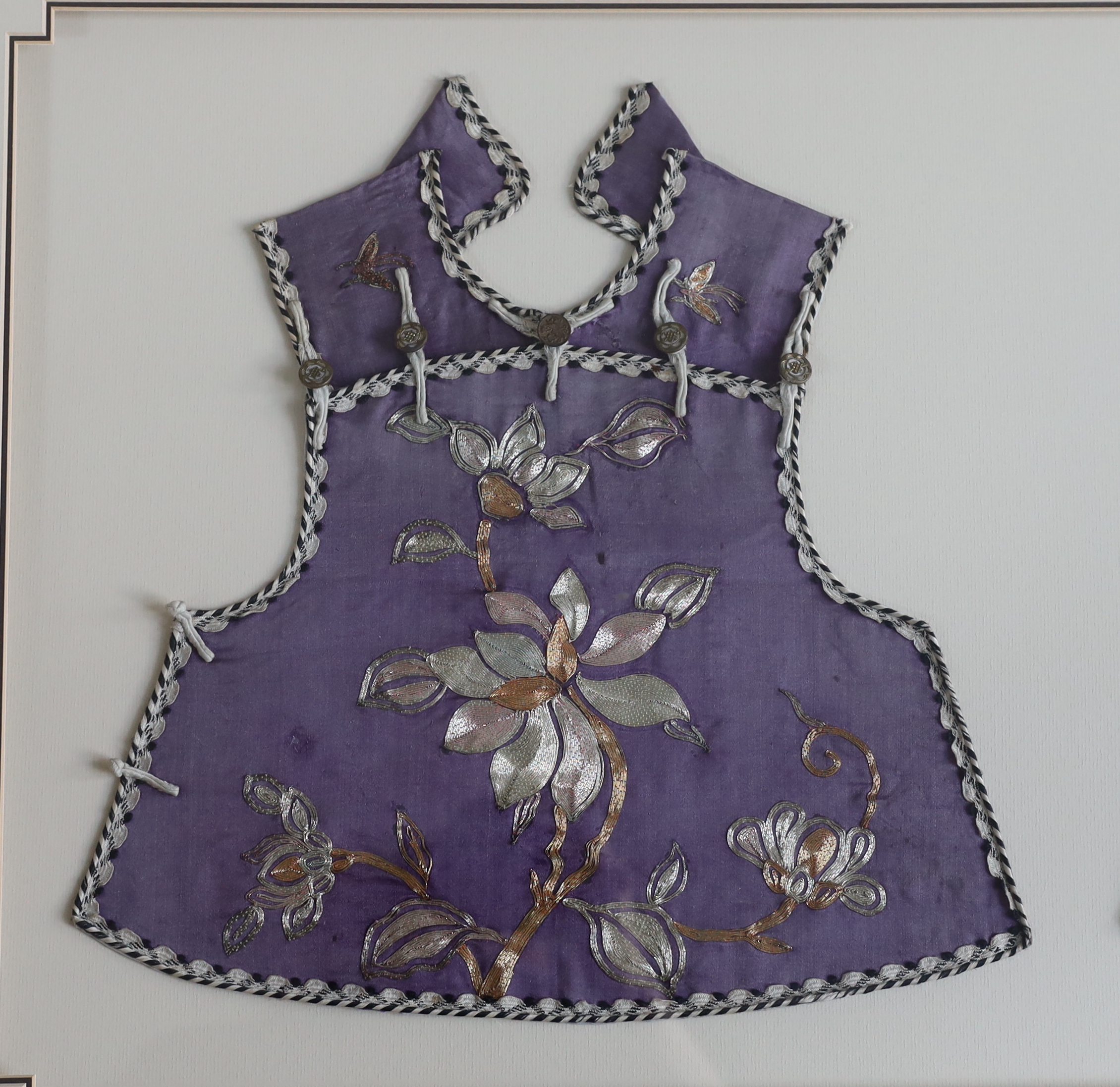 A late 19th century Chinese child’s purple silk and multi-coloured metal embroidered tabbard, - Image 2 of 3