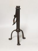 An 18th century rare iron candle holder, English, on tripod base, the cylindrical stem with push