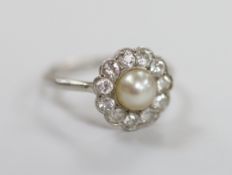 A 1920's white metal, cultured pearl and diamond set circular cluster ring, size M/N, gross weight