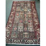 A Baktiari carpet woven panels of floral devices 300cm x 156cm