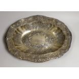 A large late 19th/early 20th century continental white metal oval bowl, embossed with birds, scrolls