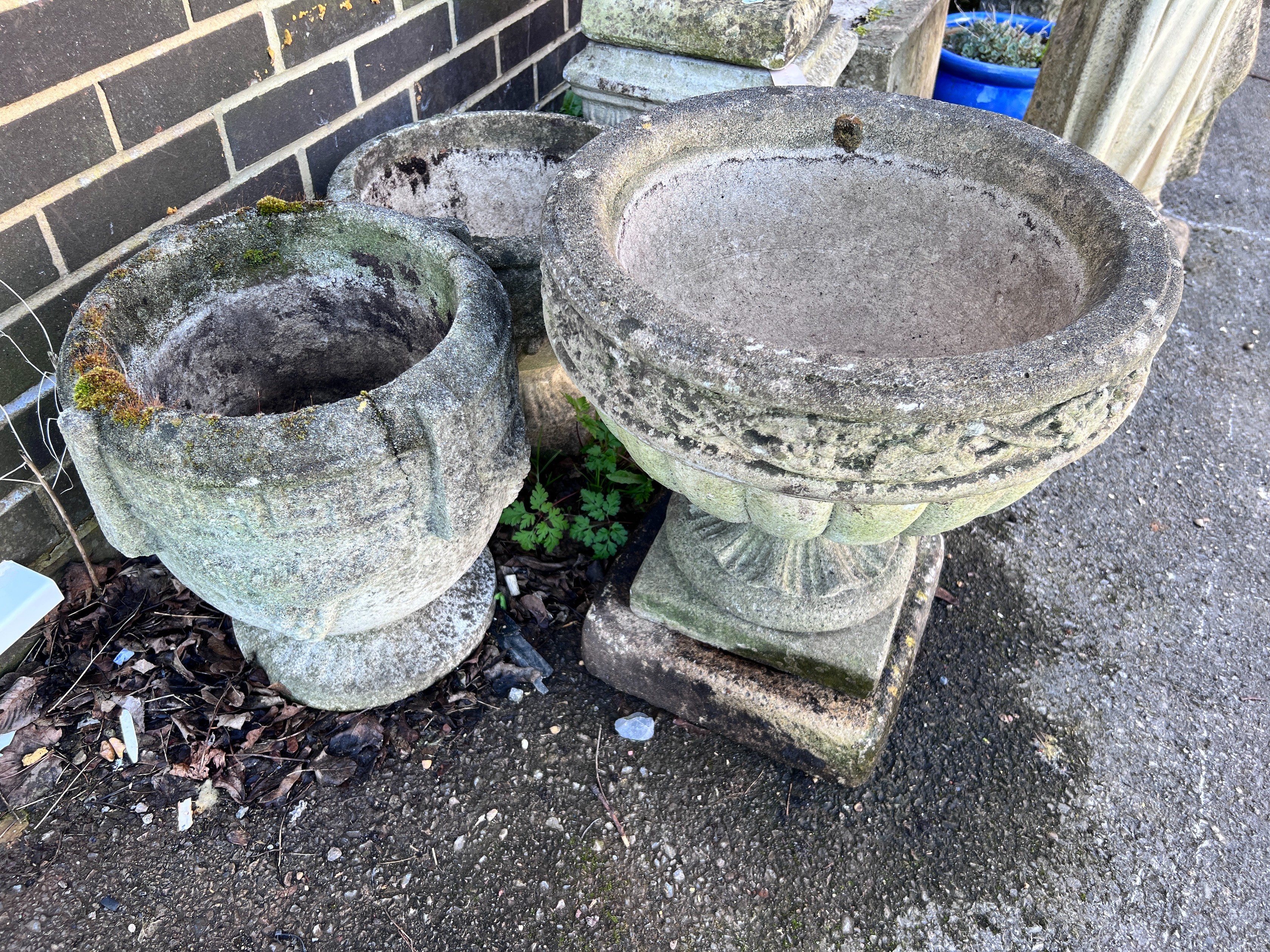 Three circular reconstituted stone garden planters, largest diameter 46cm, height 49cm