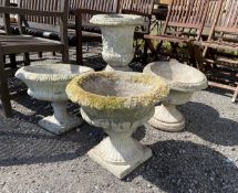Four assorted reconstituted stone garden urns on bases, largest 61cm high