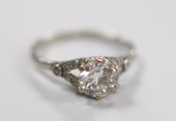 A white metal (stamped plat) and single stone diamond ring, with diamond chip set shoulders, size