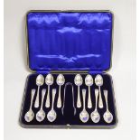 A cased set of twelve George V engraved silver Old English pattern teaspoons and pair of sugar