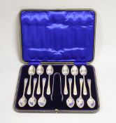 A cased set of twelve George V engraved silver Old English pattern teaspoons and pair of sugar