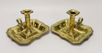 A pair of 18th century brass chamber candlesticks, the rectangular trays with wave edges, 18cm wide