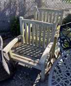 A pair of weathered teak garden elbow chairs, width 71cm, height 96cm