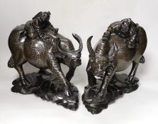 A pair of Chinese hardwood and silver inlaid ‘ox’ groups, 28cm