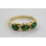 A modern 18ct gold and three stone cabochon emerald set half hoop ring, size N, gross weight 3.2