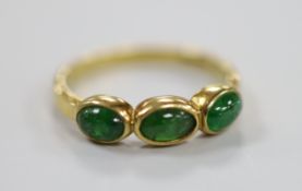 A modern 18ct gold and three stone cabochon emerald set half hoop ring, size N, gross weight 3.2