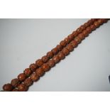 A Chinese necklace of approximately 98 carved coquilla nuts/peach stones