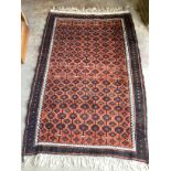 A Belouch red ground rug, 173 x 111cm