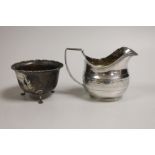 A George III chased silver cream jug, James Mince, London, 1809, 81mm and a later silver sugar bowl,
