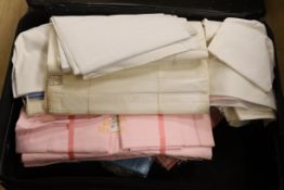 A suitcase of various coloured, unused cotton sheets