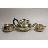 A late Victorian demi-fluted silver three piece tea set, Hukin & Heath, London, 1893/4/5, gross