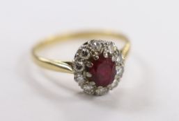 An 18ct, ruby and diamond set oval cluster ring, size N/O, gross weight 2.5 grams.