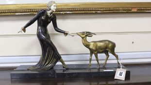Manner of Menneville. A French Art Deco bronze of a lady feeding a fawn, 45cm wide