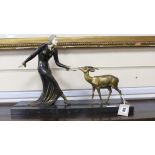 Manner of Menneville. A French Art Deco bronze of a lady feeding a fawn, 45cm wide