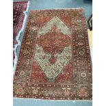 An Isphahan red and cream medallion rug, enclosed by a border of trailing stylised foliage, 200cm