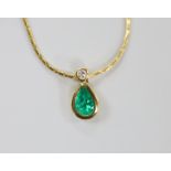A modern 18ct gold, pear cut emerald and round cut diamond set pendant, 14mm, on an 18ct gold chain,