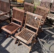 A set of four stained teak folding garden chairs