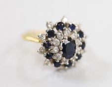 An 18ct yellow metal, sapphire and diamond set oval cluster dress ring, size M, gross weight 6
