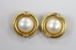 A modern pair of 750 yellow metal, mabe pearl and two stone diamond set circular ear clips, 20mm,