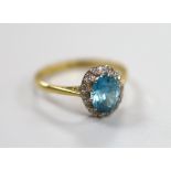 An 18ct blue zircon and diamond chip set oval cluster ring, size N, gross weight 3.1 grams.