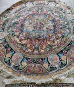 A Tabriz style circular rug woven with animals and birds within panels of fruit and flowers,