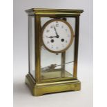 An early 20th century brass four glass clock with mercury pendulum, 28cm high