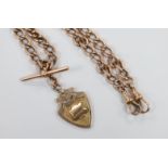 An early 20th century 9ct rose gold albert, 36cm, hung with a 9ct gold shield shaped medallion, 52.3