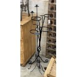 A wrought iron pot stand and two candle holders