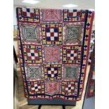 An Indian late 19th early 20th century quilt, worked with ornately designed multicoloured squares of