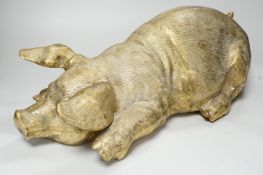A large hollow cast brass model of a recumbent pig, 47cm long