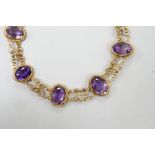 A late Victorian yellow metal and eight stone oval cut amethyst set fancy link bracelet, 18cm, gross