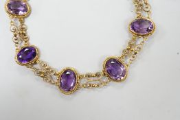 A late Victorian yellow metal and eight stone oval cut amethyst set fancy link bracelet, 18cm, gross