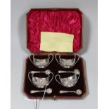A cased set of four Edwardian demi-fluted silver two handled salts and four spoons, James Dixon &