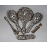 A late Victorian repousse silver mounted six piece mirror and brush set, Chester, 1900.