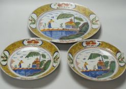A Delft charger and a pair of similar dishes, largest 34cm diameter