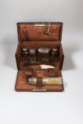 A George V leather travelling toilet case, containing five silver mounted glass jars, Birmingham,