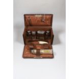 A George V leather travelling toilet case, containing five silver mounted glass jars, Birmingham,