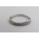 A modern 18ct white gold and seven stone diamond chip set half hoop ring, size K, gross weight 2.4