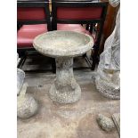 A circular reconstituted stone bird bath, on simulated trunk base, diameter 47cm, height 61cm