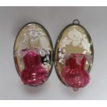 A pair of Victorian style cranberry glass wall lights with oval mirror back plates